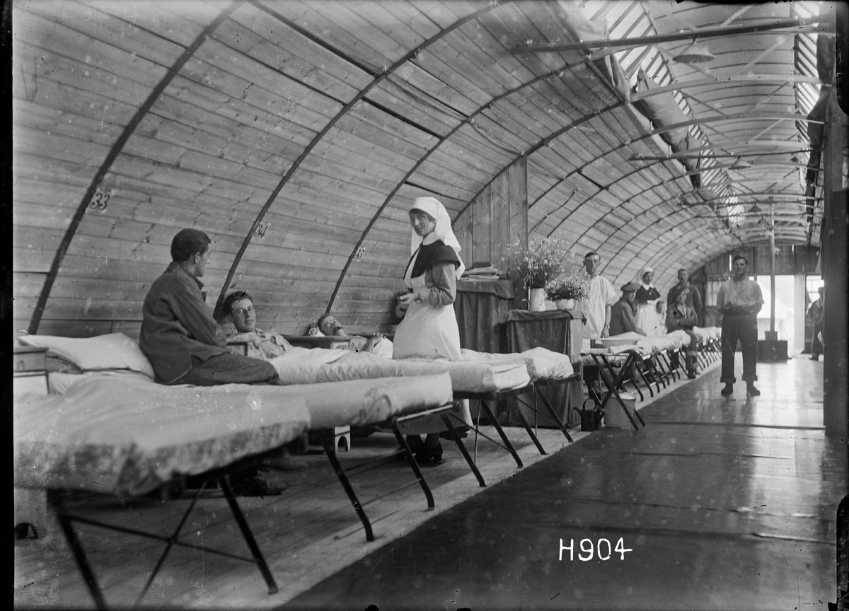 A nurse with patients at the New Zealand Stationary Hospital in Wisques, France, 17 August 1918.